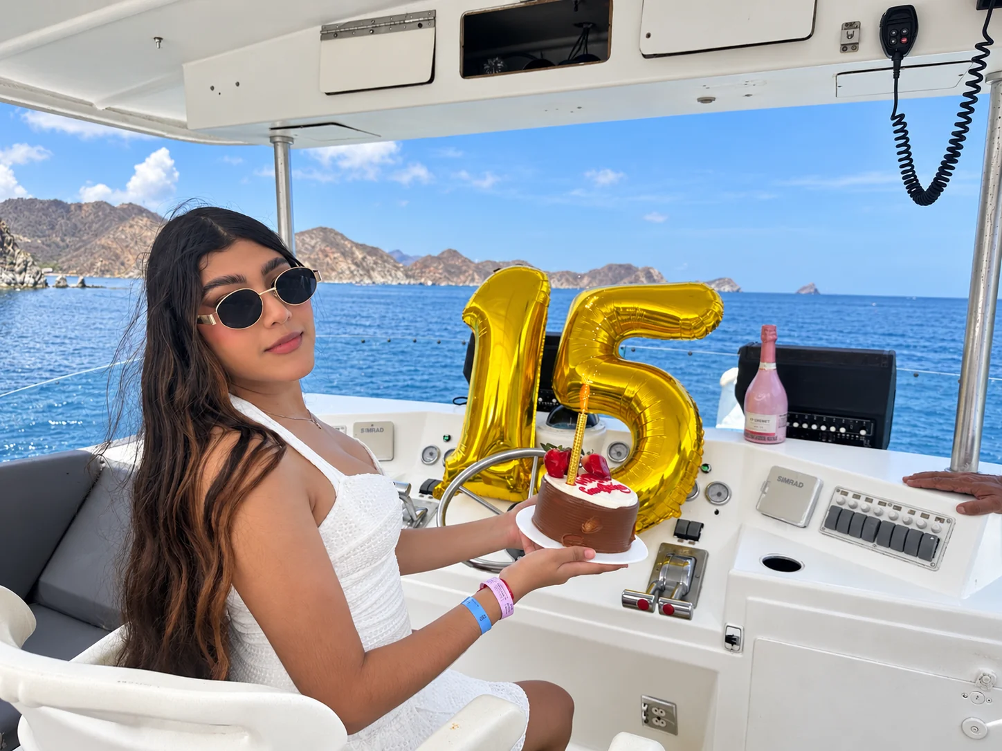Celebración de quince años en yate con torta y globos dorados en Santa Marta